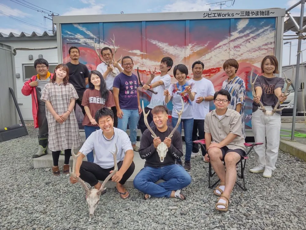 ジビエWorksの前で、鹿の角を手に集まるMOMIJIのメンバーと参加者