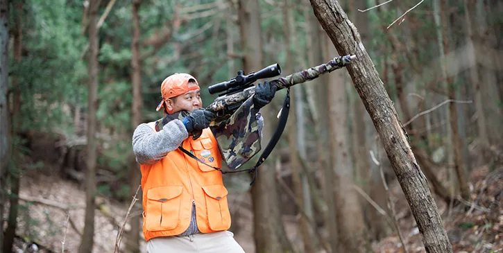 山中で猟銃を構えるハンター